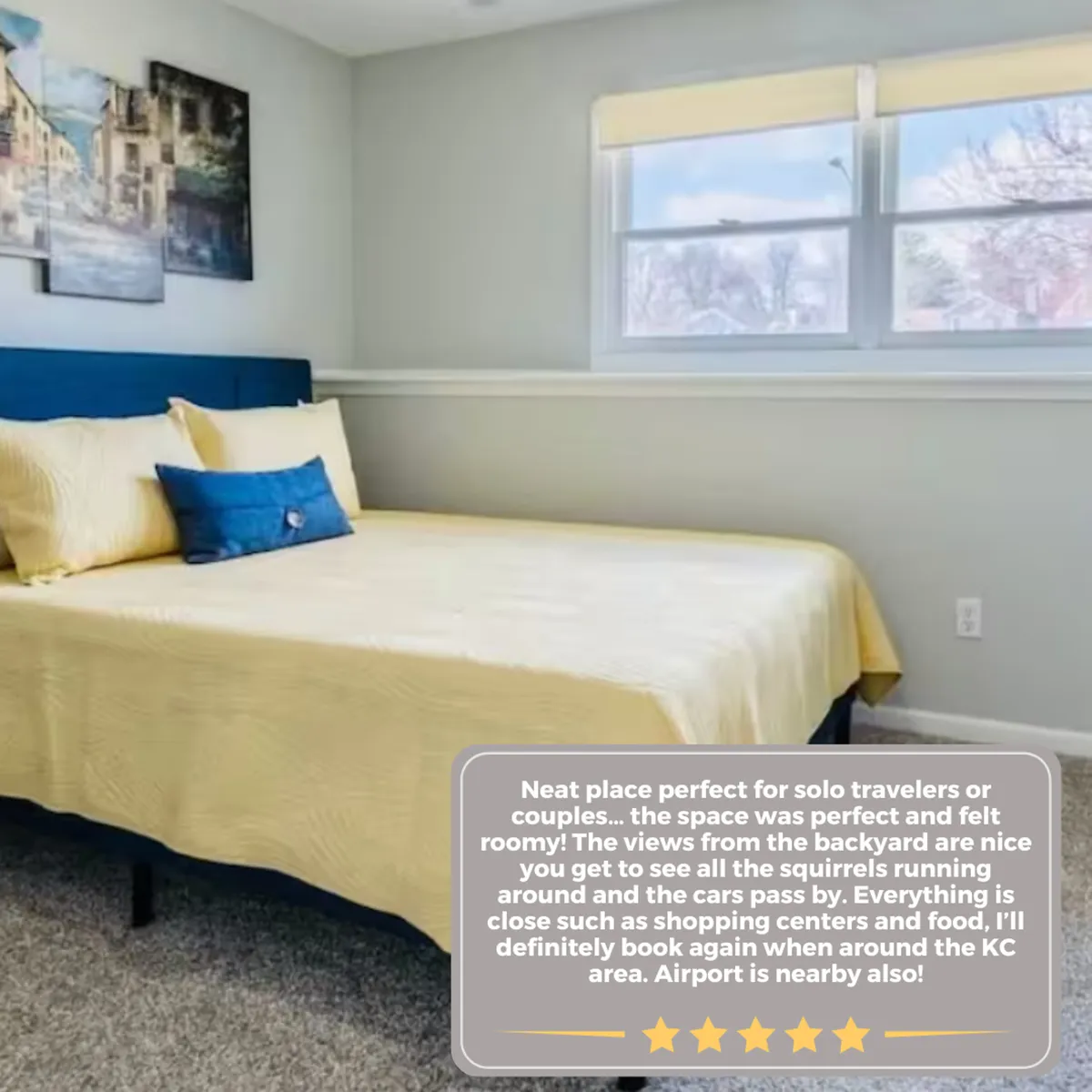 A cozy bedroom interior featuring a bed with bright yellow bedding, decorative pillows, wall art, and large windows that fill the space with natural light. The atmosphere is comfortable and welcoming, inviting guests to relax and enjoy the view, perhaps while sipping a morning coffee.